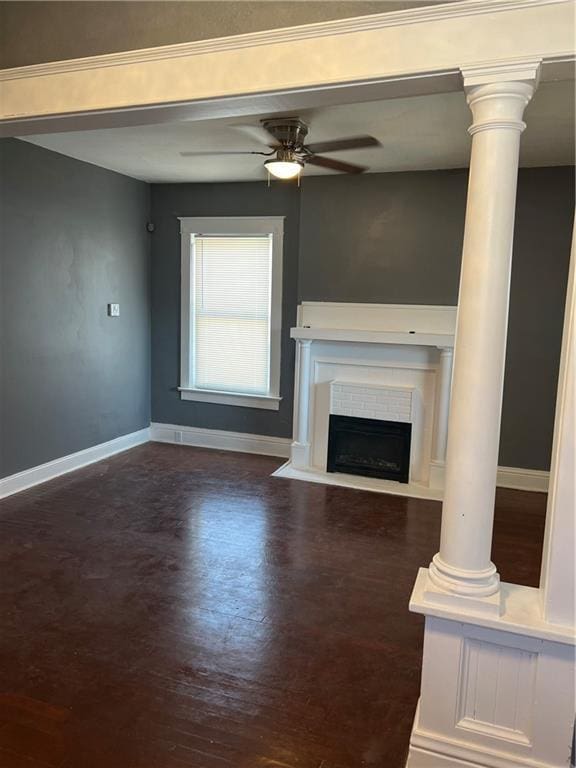 unfurnished living room featuring wood finished floors, a ceiling fan, baseboards, and ornate columns