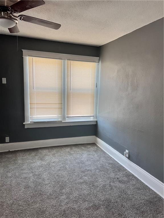 unfurnished room featuring baseboards, carpet, ceiling fan, and a textured ceiling