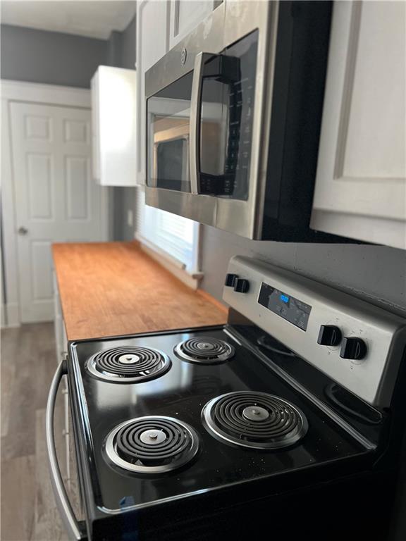 kitchen with white cabinets, appliances with stainless steel finishes, and butcher block countertops