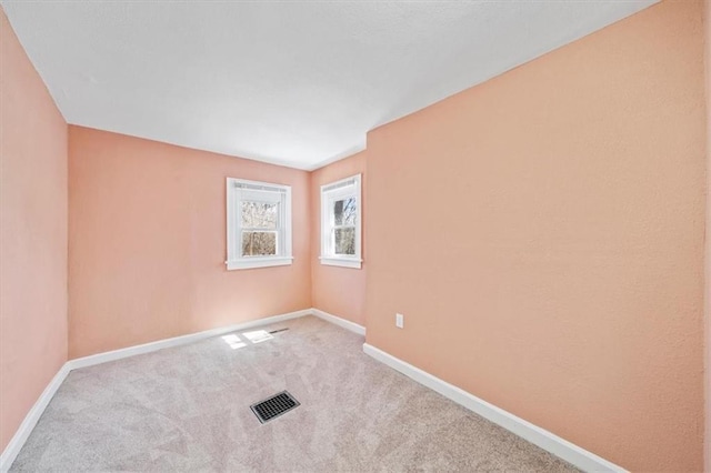 unfurnished room featuring carpet, visible vents, and baseboards