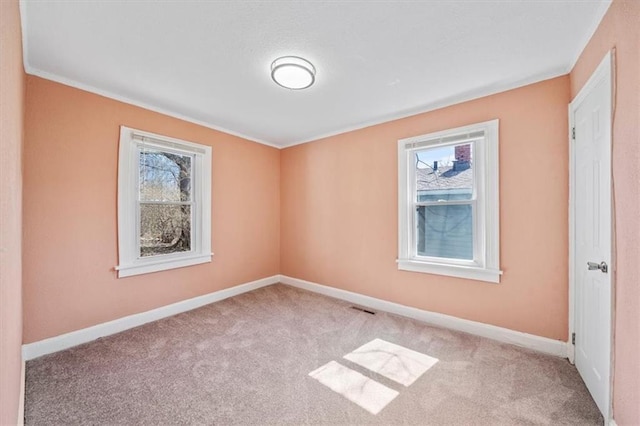 carpeted empty room with visible vents and baseboards