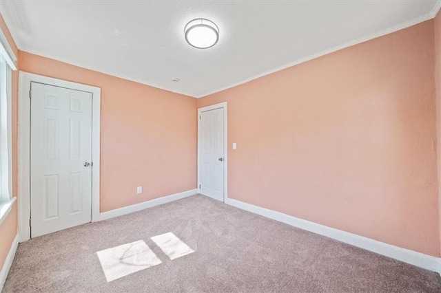 empty room with baseboards and carpet