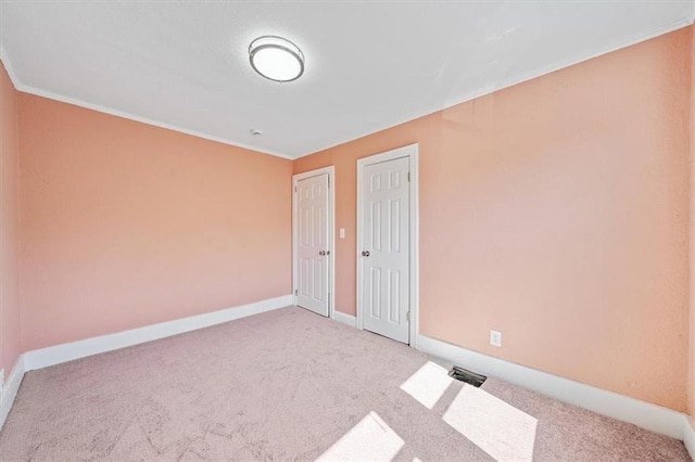 carpeted spare room with baseboards and ornamental molding