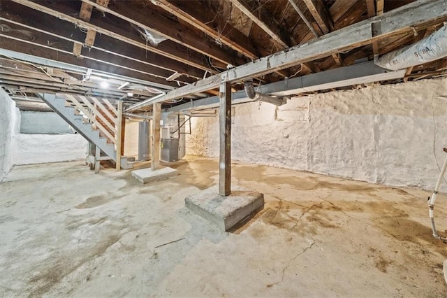 unfinished basement with heating unit and stairs