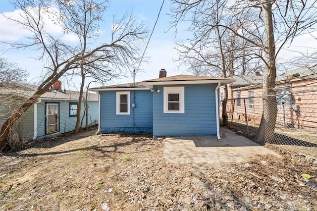 rear view of property featuring fence and a chimney