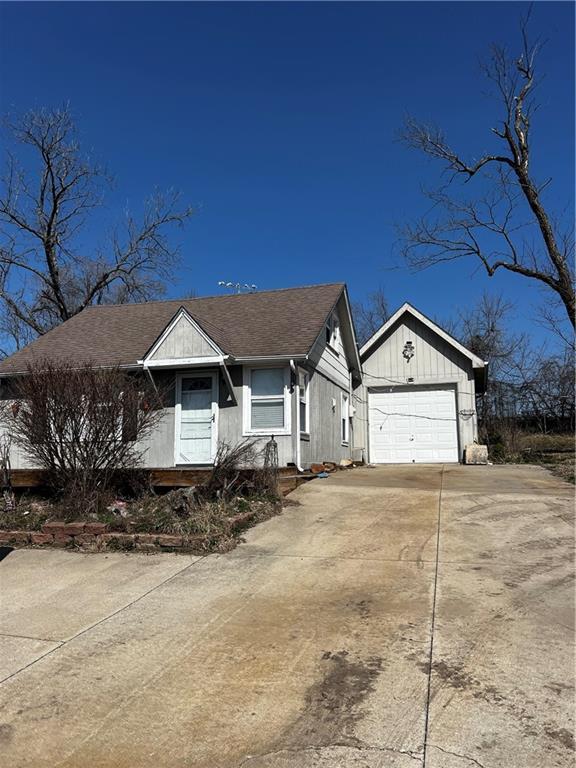 view of front of home with an attached garage, concrete driveway, and a shingled roof