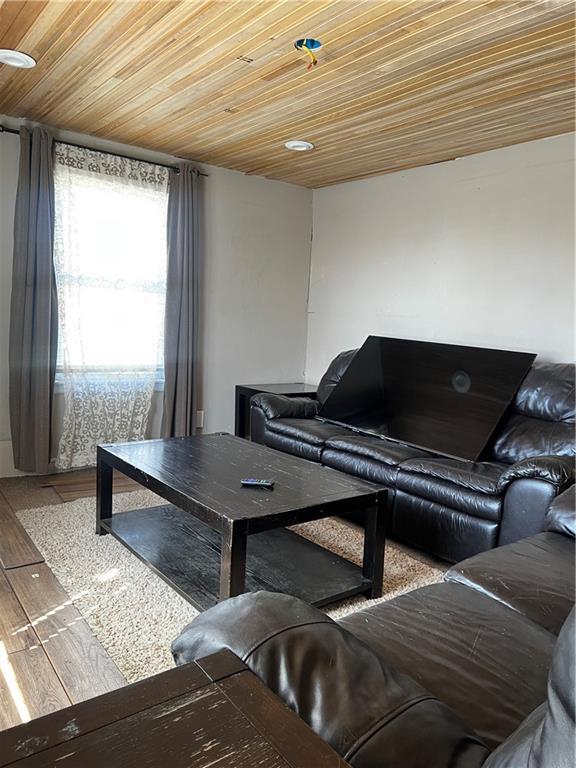 living room with wooden ceiling and wood finished floors