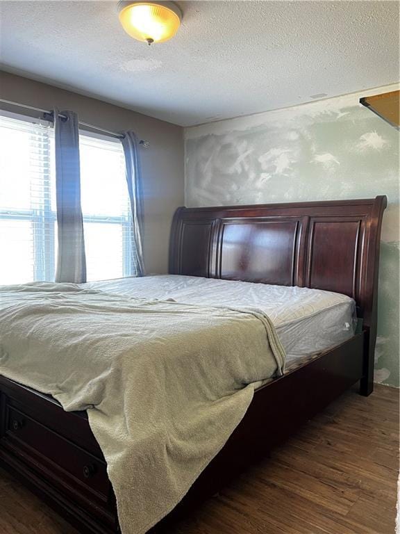 bedroom featuring wood finished floors and a textured ceiling