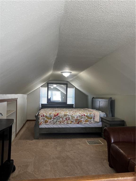 carpeted bedroom with lofted ceiling and a textured ceiling