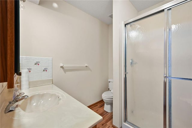 full bath with vanity, toilet, wood finished floors, and a stall shower