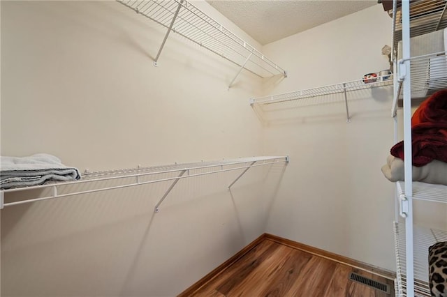 walk in closet featuring visible vents and wood finished floors