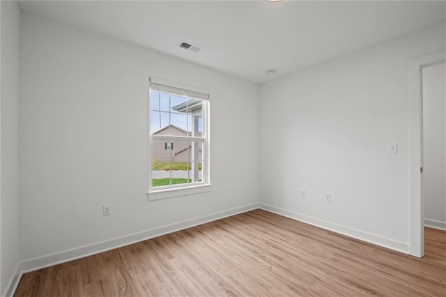 empty room with visible vents, baseboards, and light wood finished floors