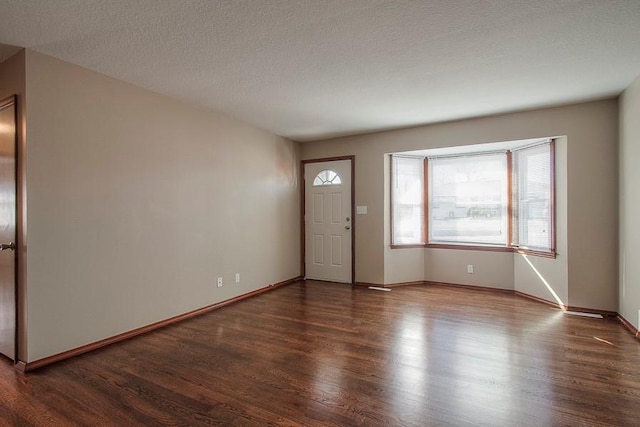 entrance foyer with wood finished floors, baseboards, and a textured ceiling