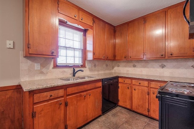 kitchen featuring a textured ceiling, black appliances, brown cabinetry, and a sink