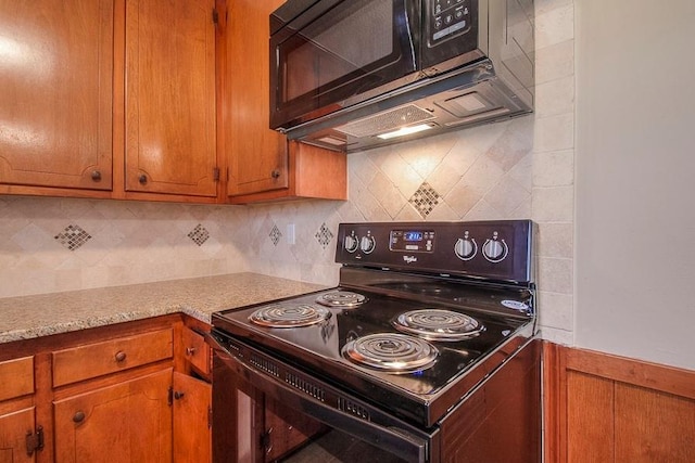 kitchen featuring brown cabinets, backsplash, black appliances, and light countertops