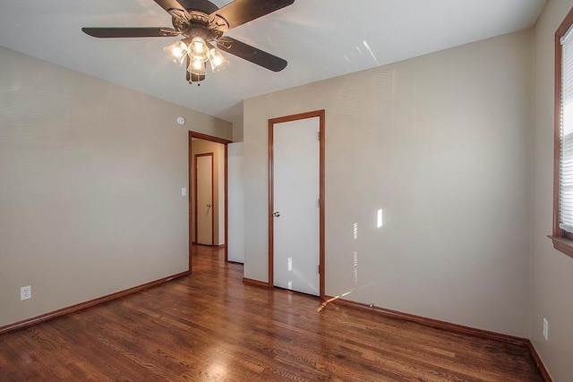 spare room with baseboards, ceiling fan, and wood finished floors