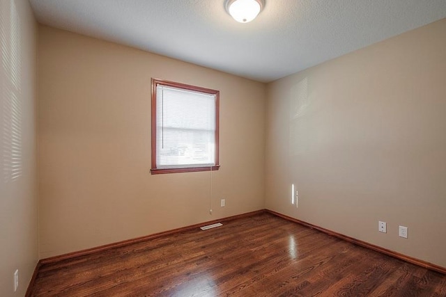 unfurnished room with baseboards and wood finished floors