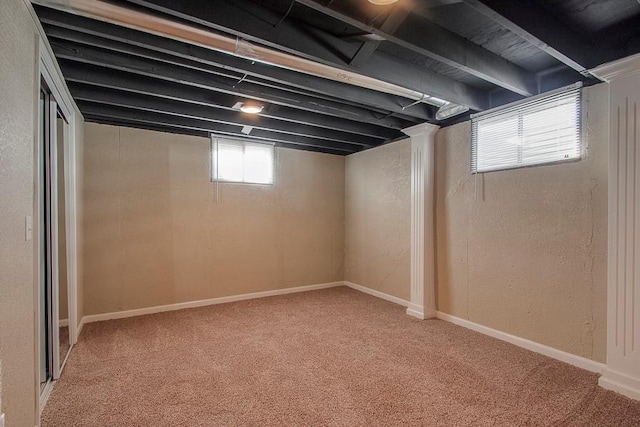 basement with baseboards, carpet, and a textured wall