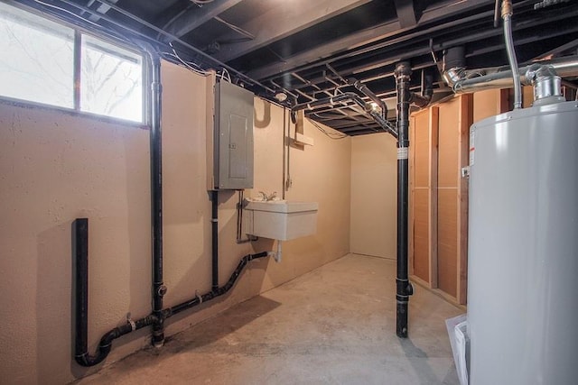 basement with gas water heater, electric panel, and a sink