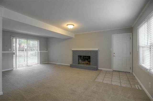 unfurnished living room with a brick fireplace, crown molding, baseboards, carpet, and tile patterned floors