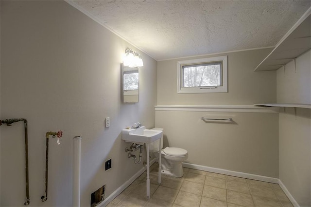 half bath with crown molding, toilet, baseboards, and a textured ceiling