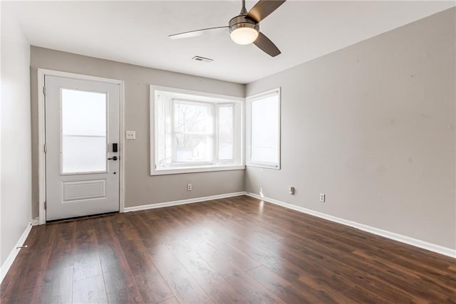 foyer entrance featuring visible vents, baseboards, dark wood-style floors, and a ceiling fan