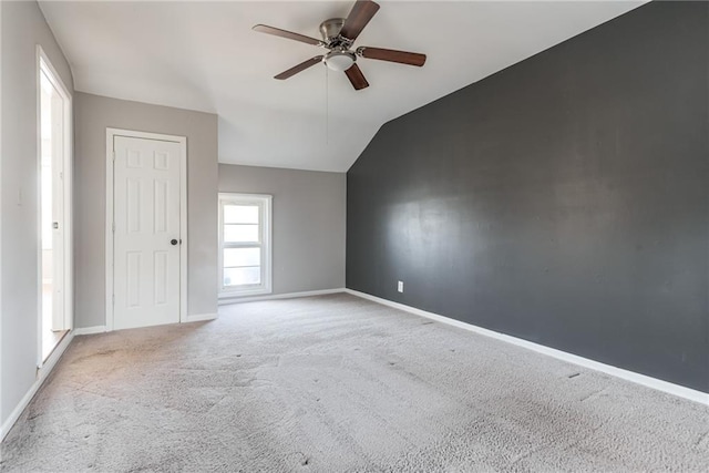 unfurnished room featuring baseboards, carpet floors, ceiling fan, and vaulted ceiling