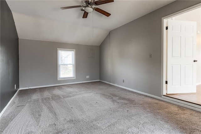 carpeted empty room with baseboards, a ceiling fan, and vaulted ceiling