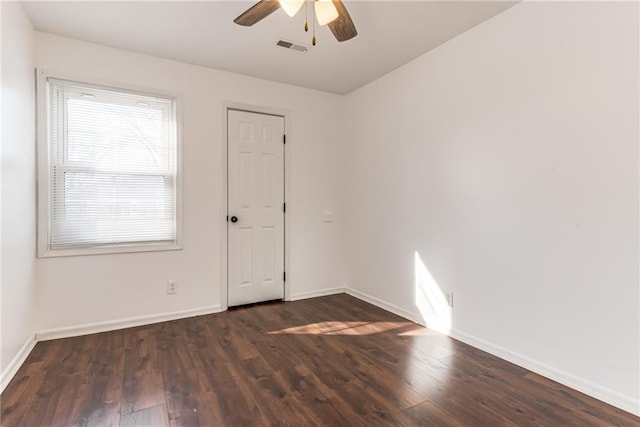 empty room with visible vents, baseboards, wood finished floors, and a ceiling fan