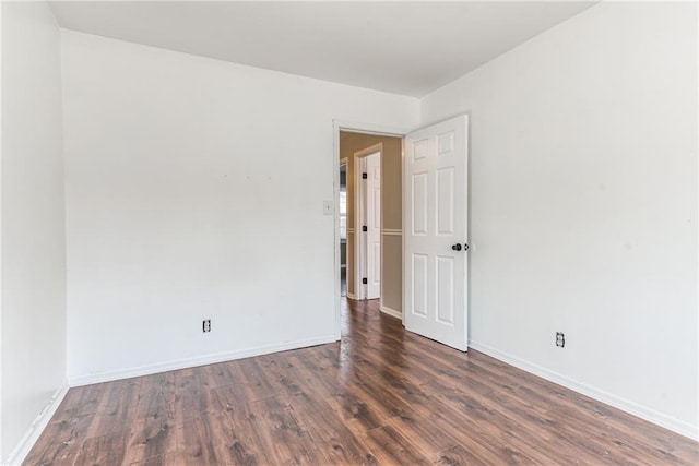 spare room featuring baseboards and wood finished floors