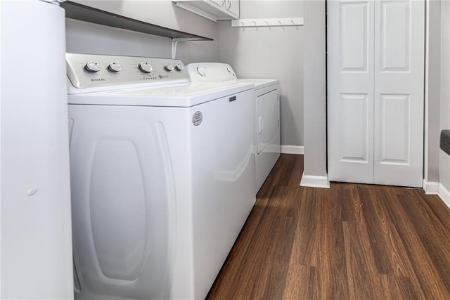 washroom featuring dark wood finished floors, laundry area, washing machine and dryer, and baseboards