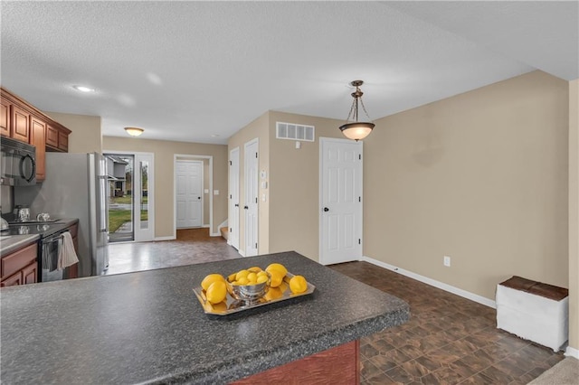 kitchen featuring visible vents, black appliances, dark countertops, a textured ceiling, and brown cabinetry
