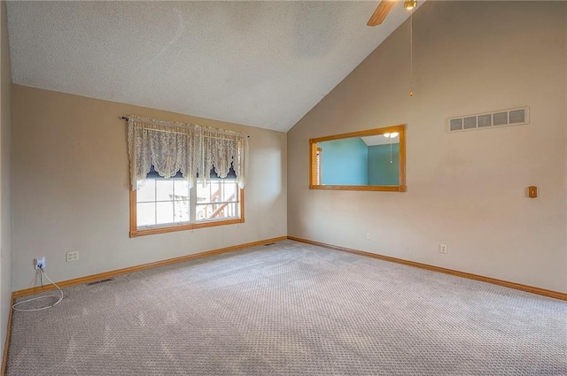 spare room featuring visible vents, a textured ceiling, ceiling fan, and vaulted ceiling