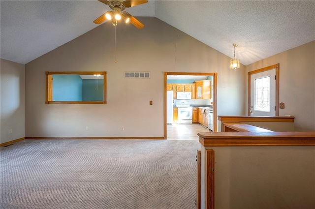 interior space with ceiling fan, vaulted ceiling, visible vents, and light carpet