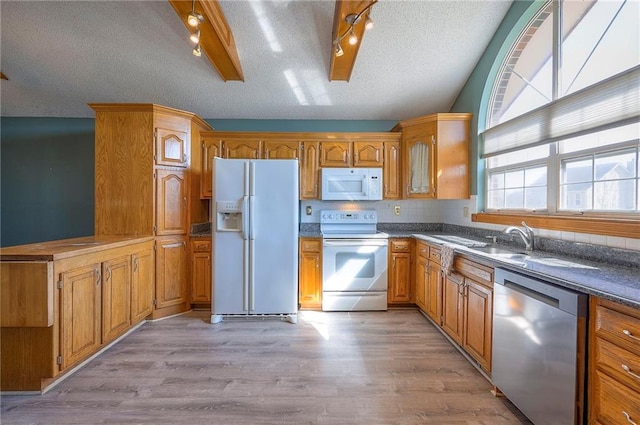 kitchen with light wood-type flooring, white appliances, a textured ceiling, and brown cabinetry