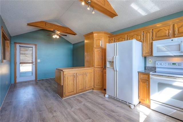 kitchen with vaulted ceiling, a peninsula, light wood-style floors, white appliances, and a ceiling fan