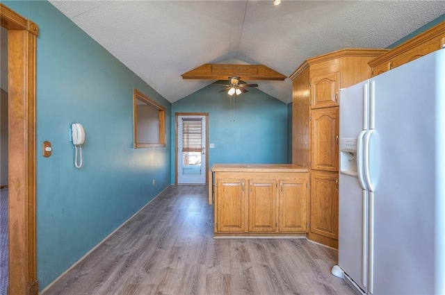 kitchen with vaulted ceiling, light wood-style flooring, white refrigerator with ice dispenser, a textured ceiling, and a ceiling fan