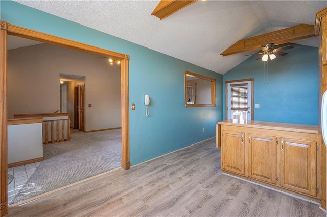 kitchen featuring lofted ceiling, a ceiling fan, light wood-style floors, and baseboards