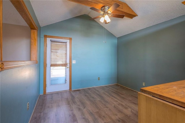 interior space with wood finished floors, a ceiling fan, lofted ceiling, and a textured ceiling