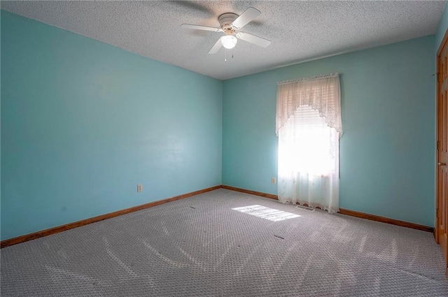 empty room featuring baseboards, a textured ceiling, ceiling fan, and carpet flooring