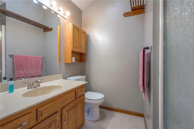 bathroom featuring tile patterned flooring, toilet, vanity, and baseboards