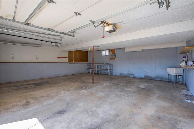 garage with electric panel, a garage door opener, and a sink