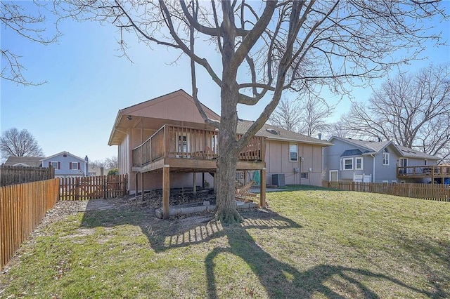 rear view of property with a fenced backyard, central air condition unit, a yard, and a deck