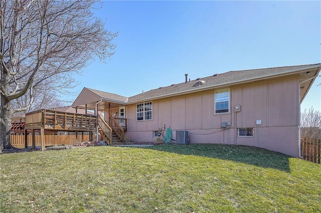 rear view of house with fence, stairway, central AC unit, a lawn, and a deck