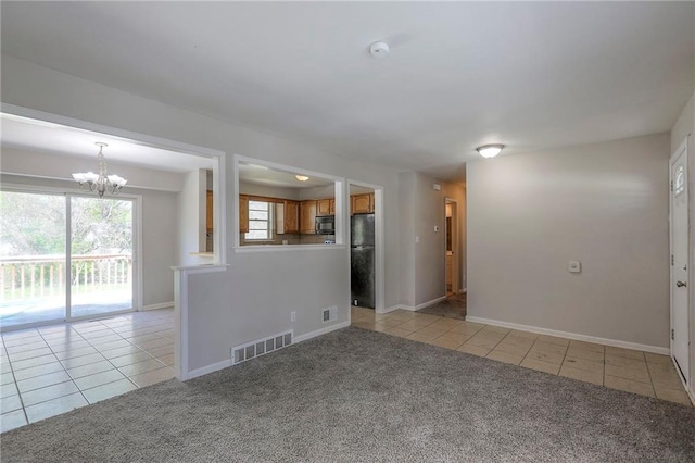 empty room with light tile patterned flooring, a chandelier, light carpet, and baseboards