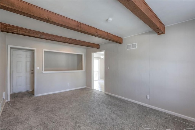 carpeted spare room featuring beamed ceiling, baseboards, and a smoke detector