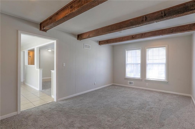 tiled empty room featuring carpet floors, beam ceiling, and baseboards