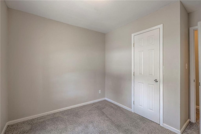 unfurnished room featuring carpet floors and baseboards