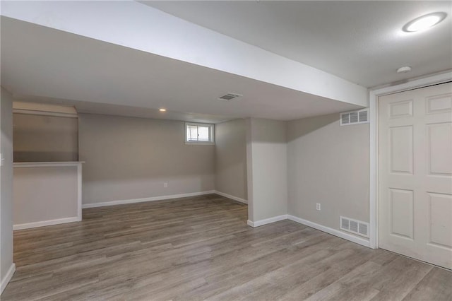 below grade area with baseboards and wood finished floors