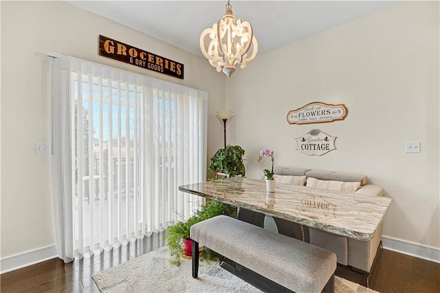 dining space featuring a notable chandelier, baseboards, and dark wood-style flooring